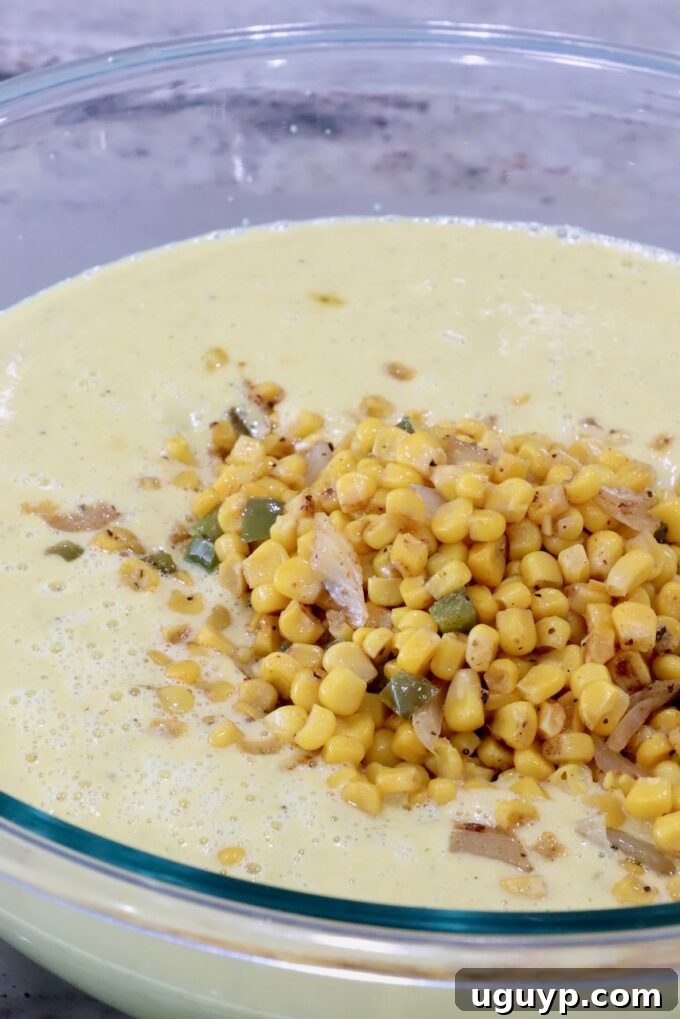 A large, inviting glass bowl brimming with pureed corn soup, generously topped with a portion of the beautifully roasted corn kernels, creating an appealing contrast in texture and color.