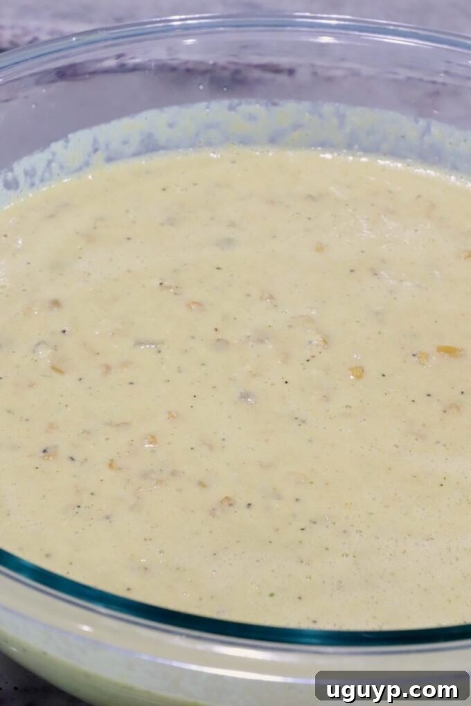 A wide shot of a large glass bowl filled with rich and creamy Mexican Street Corn Soup, showcasing its inviting consistency and vibrant appeal before final garnishes are added.