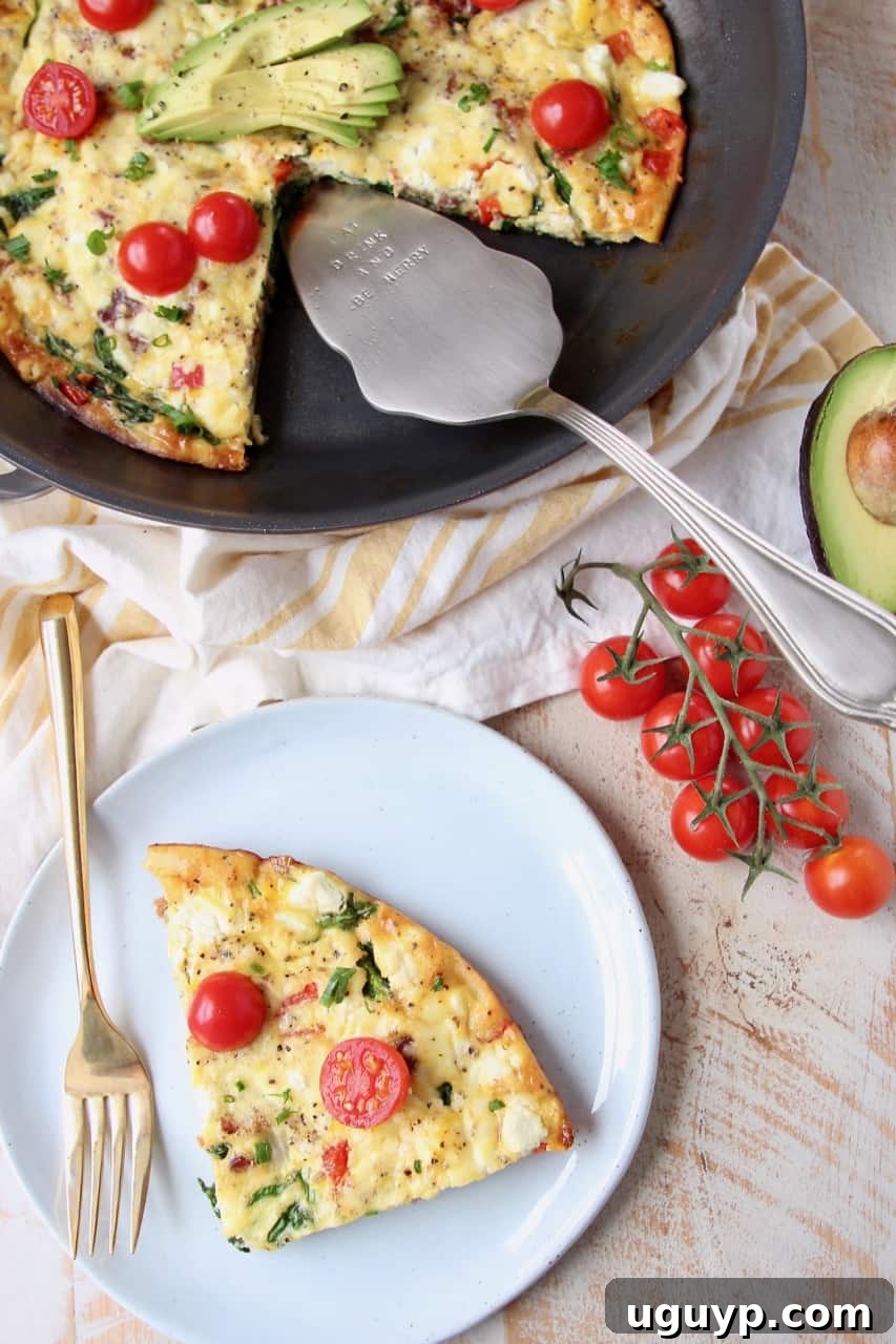 A slice of spinach frittata with goat cheese and bacon on a white plate, next to a full frittata still in the skillet.