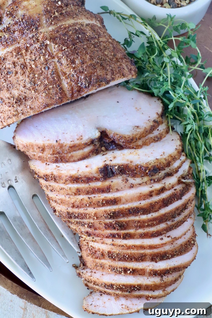 Exquisitely sliced smoked turkey breast, artfully arranged on a pristine white platter, showcasing its rich, spiced crust. Fresh green herbs elegantly garnish the dish, accompanied by a sophisticated serving fork, inviting indulgence.