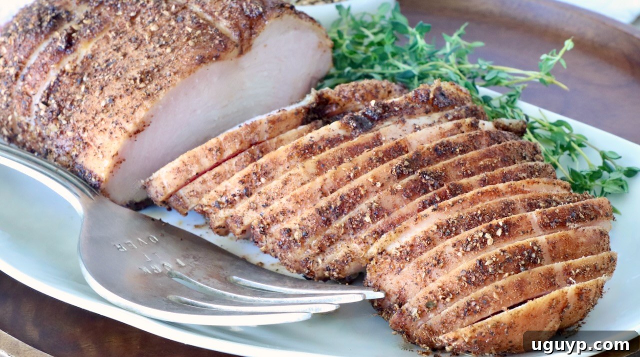 Beautifully sliced smoked turkey breast, liberally seasoned with a medley of spices, meticulously arranged on a clean white plate. The dish is elegantly garnished with fresh sprigs of thyme, and a gleaming silver carving fork rests invitingly beside it, ready for serving.