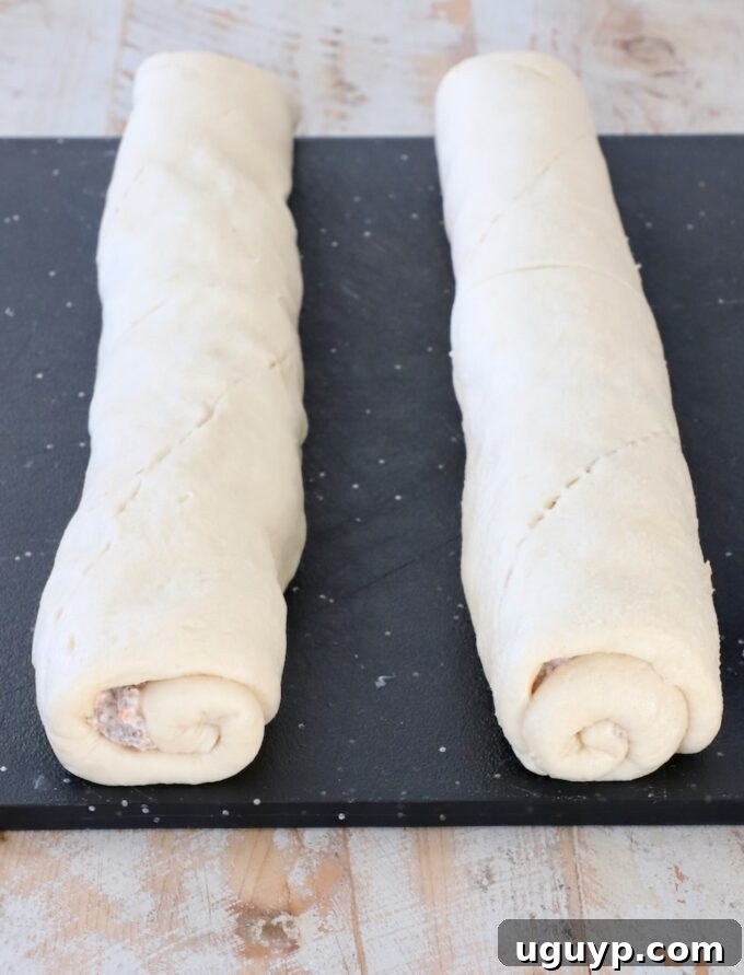 rolled up crescent roll dough on a cutting board
