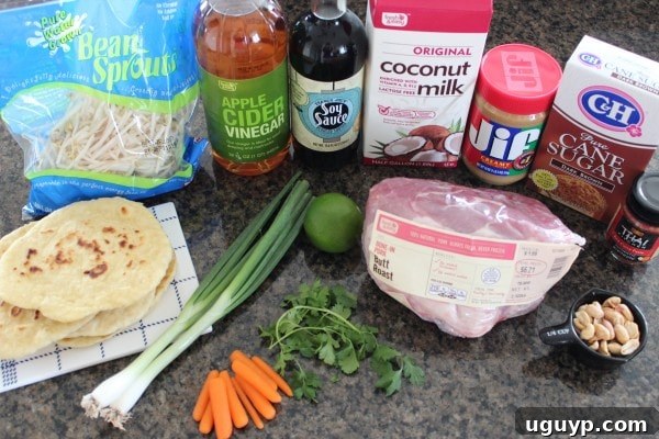 Array of ingredients for Thai Peanut Pulled Pork Roti Bread Pizza, neatly arranged on a cutting board.