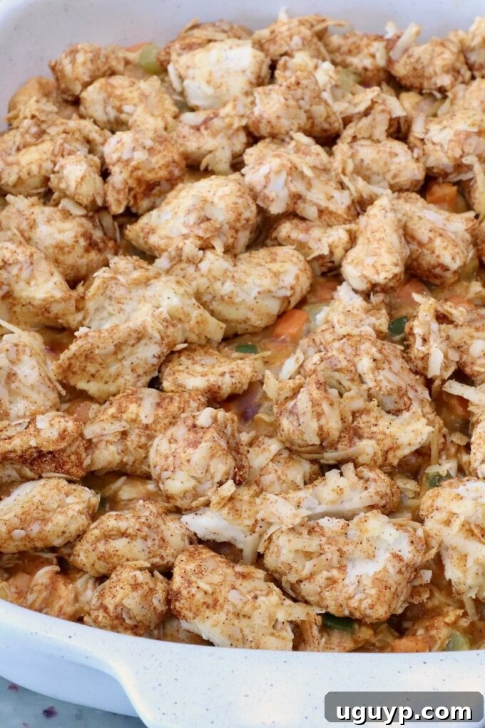seasoned cubes of biscuit dough on top of pot pie filling in a baking dish