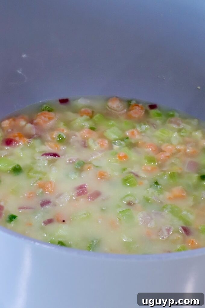 diced vegetables in a roux mixture in a large pot