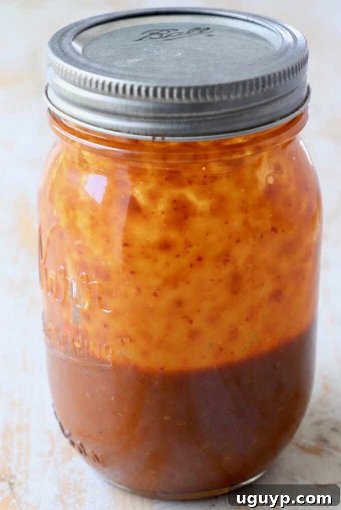Pad Thai sauce in a mason jar with a lid, showcasing its smooth texture and rich color, ready to be poured.