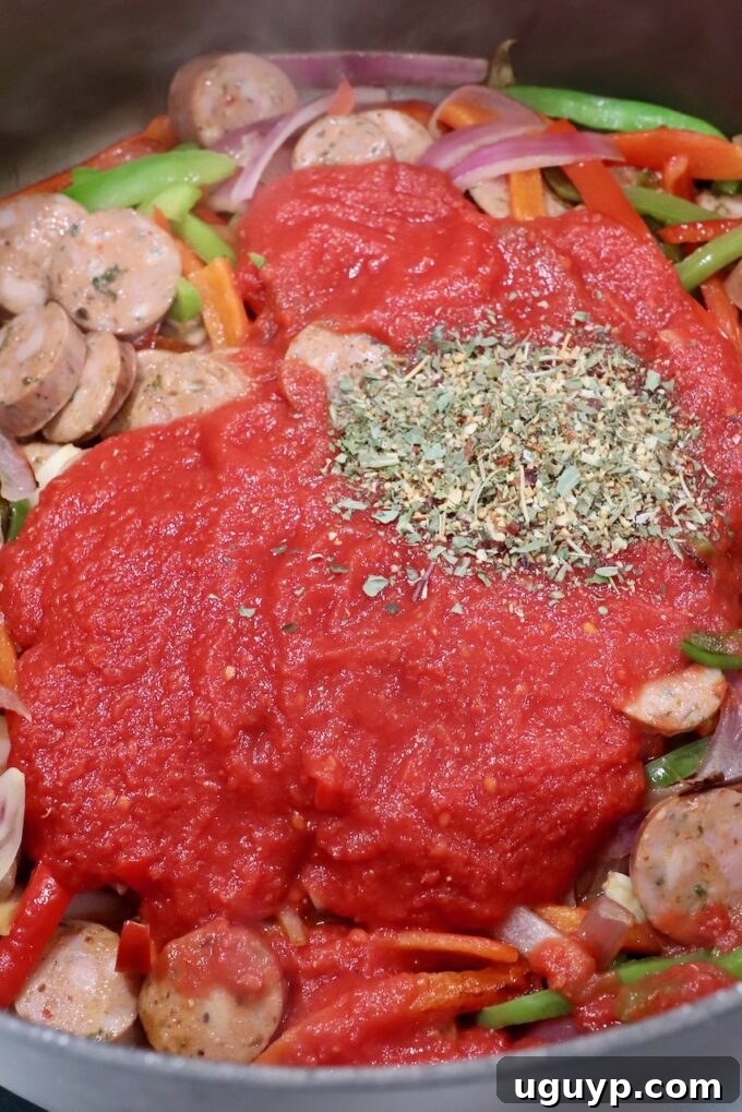 crushed tomatoes and Italian seasoning added to pan with sausage and peppers