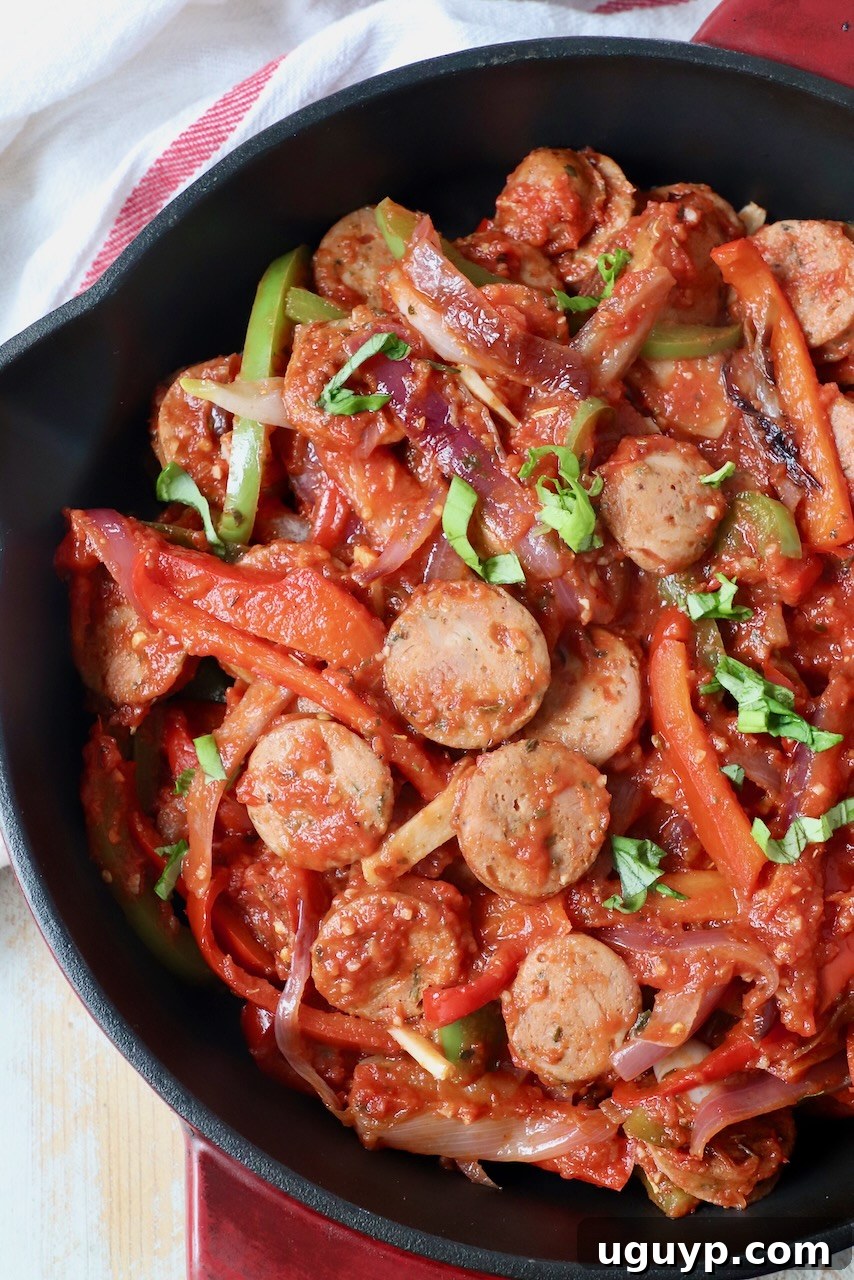 sliced sausage and peppers in tomato sauce in skillet, ready to be served