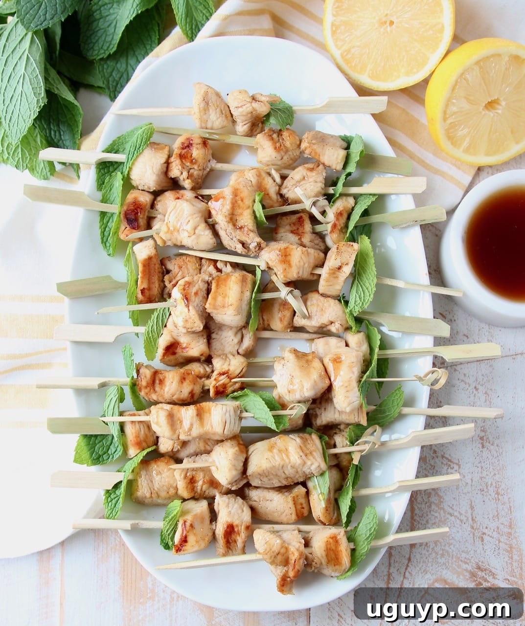 Grilled bourbon chicken on skewers with mint leaves, ready to be served