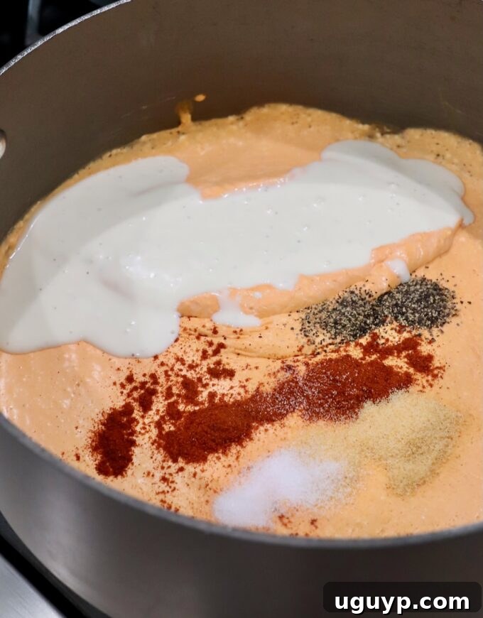 The spiced creamy buffalo sauce in a large pot, now with blue cheese dressing added, creating an even richer and tangier flavor.