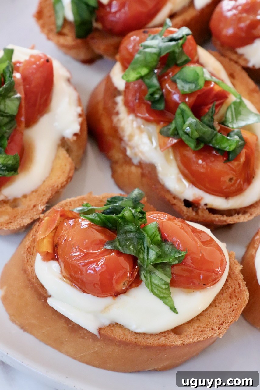 roasted tomatoes and whipped ricotta cheese on slices of baguette on a plate