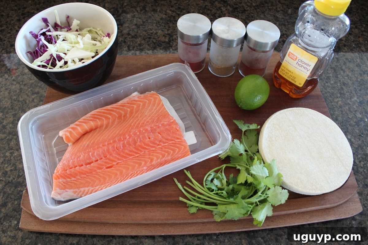 Assortment of fresh ingredients for Chipotle Honey Glazed Salmon Tacos displayed on a rustic wood board