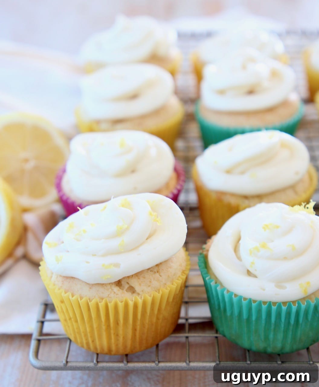 Freshly baked lemon cupcakes with creamy lemon frosting on a wire cooling rack