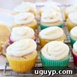 Lemon cupcakes with cream cheese frosting sitting on wire cooling rack