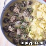Meatballs au Poivre in a skillet with cooked egg noodles