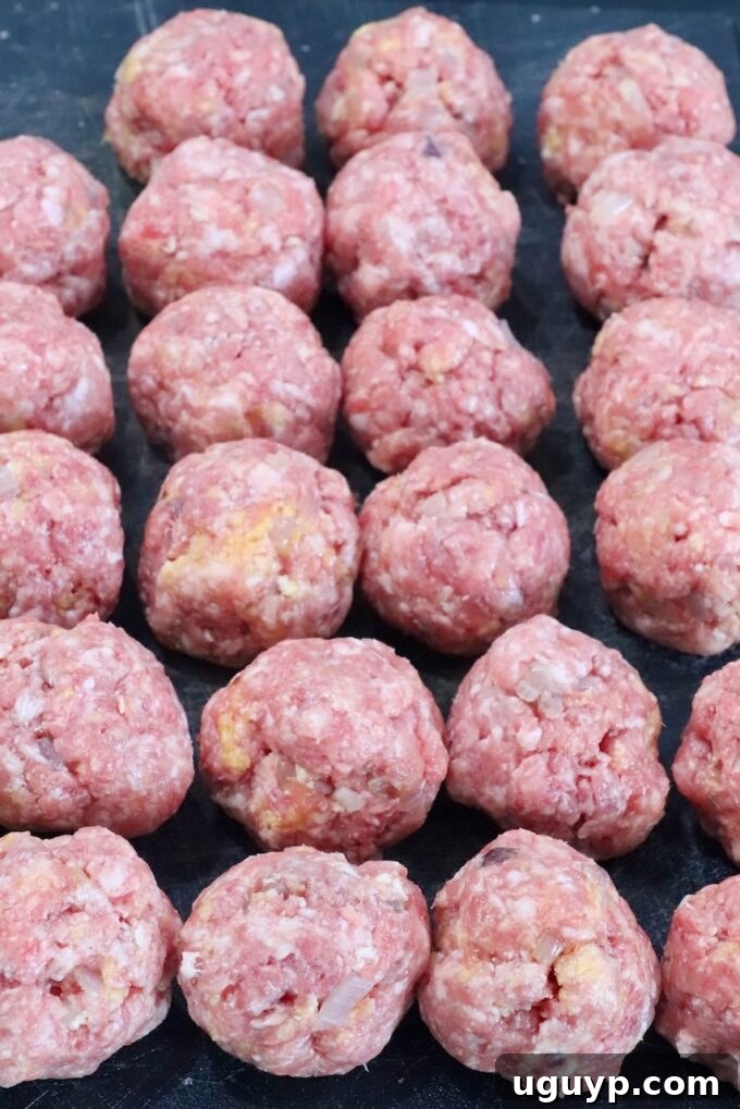 raw meatballs on a dark cutting board