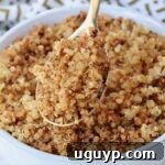 crispy quinoa in a gold spoon lifted out of a bowl of crispy quinoa