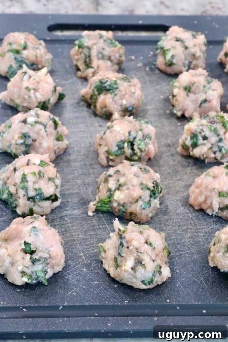 raw Thai basil chicken meatballs on a black cutting board