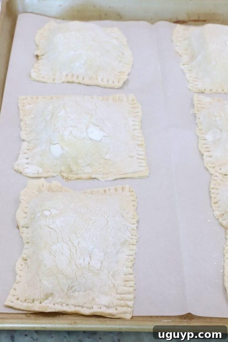 unbaked tarts on a parchment-lined baking sheet