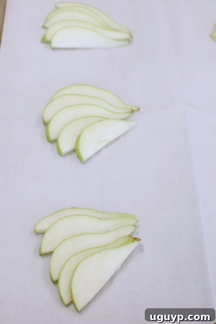 sliced pears on a sheet of parchment paper on a baking sheet