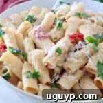 A bowl of creamy tuscan pasta topped with fresh parsley and grated cheese