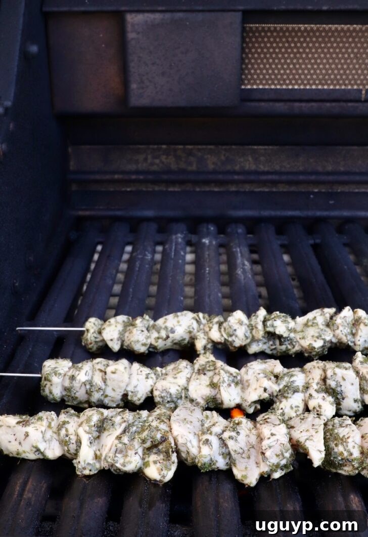 raw chicken skewers on a grill