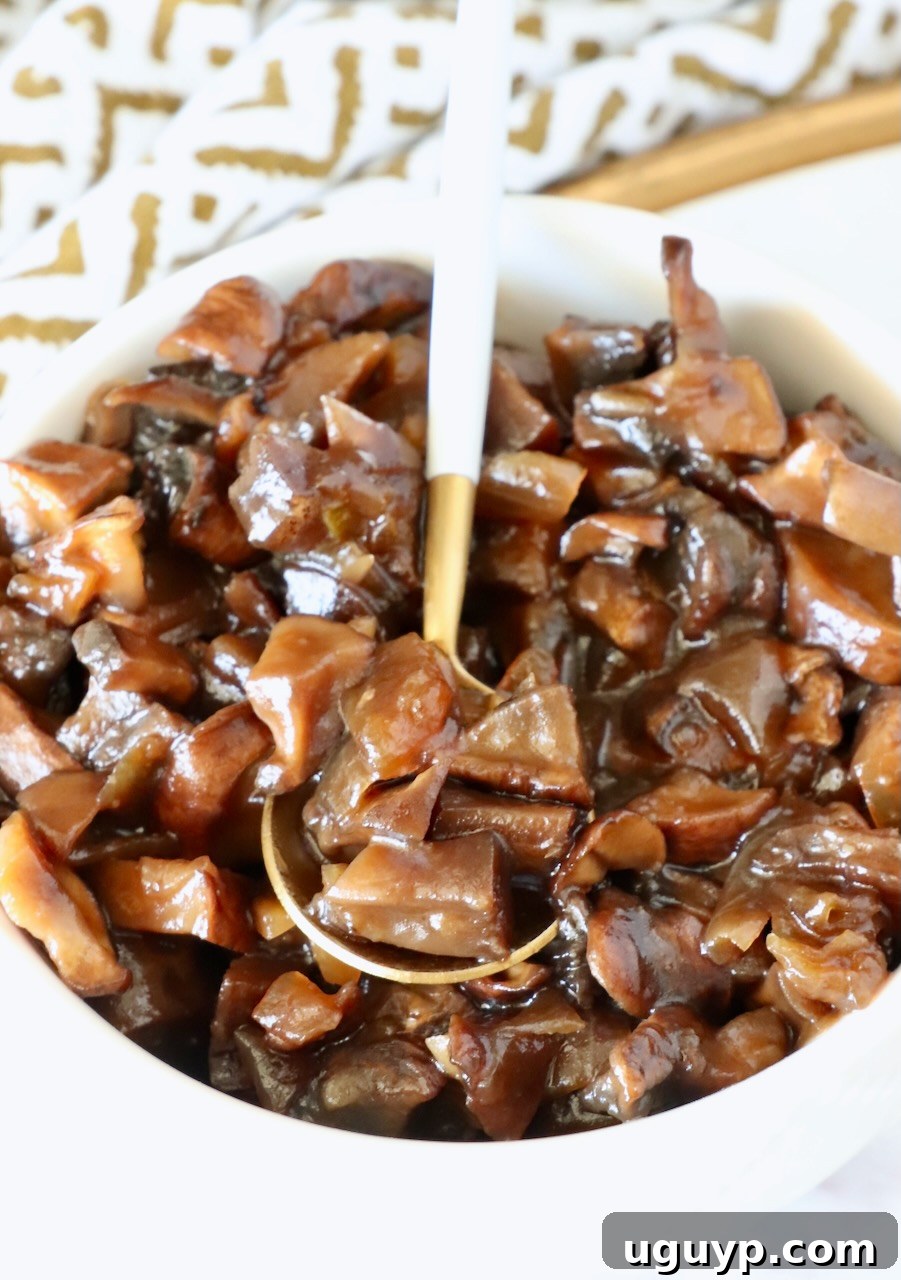 mushroom jam in a white bowl with a gold and white spoon