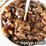 mushroom jam in a white bowl with a gold and white spoon