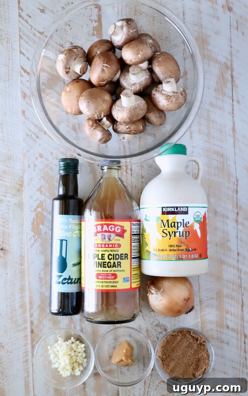 ingredients on a white wood board for mushroom jam, includes a bowl of mushrooms, maple syrup, apple cider vinegar, olive oil, onion, garlic, miso paste, and brown sugar in a small bowl
