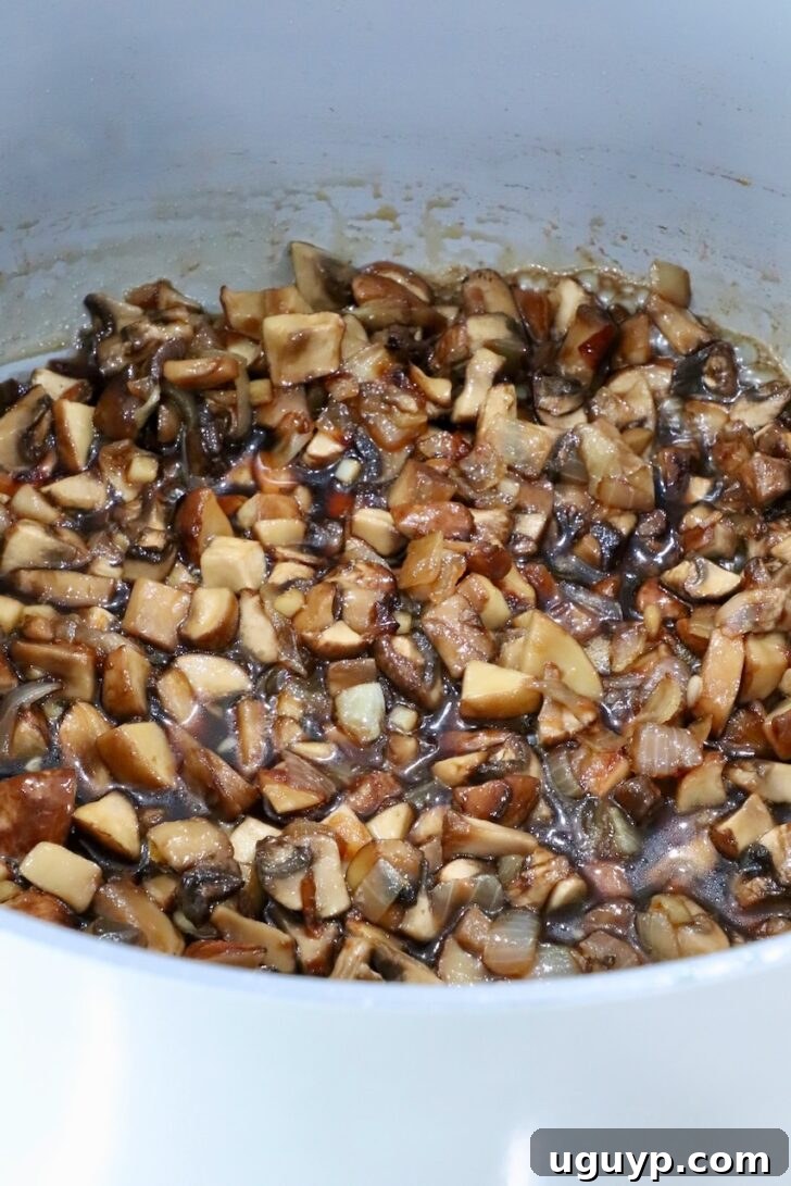 cooked mushrooms in a pot with maple syrup, brown sugar, and vinegar