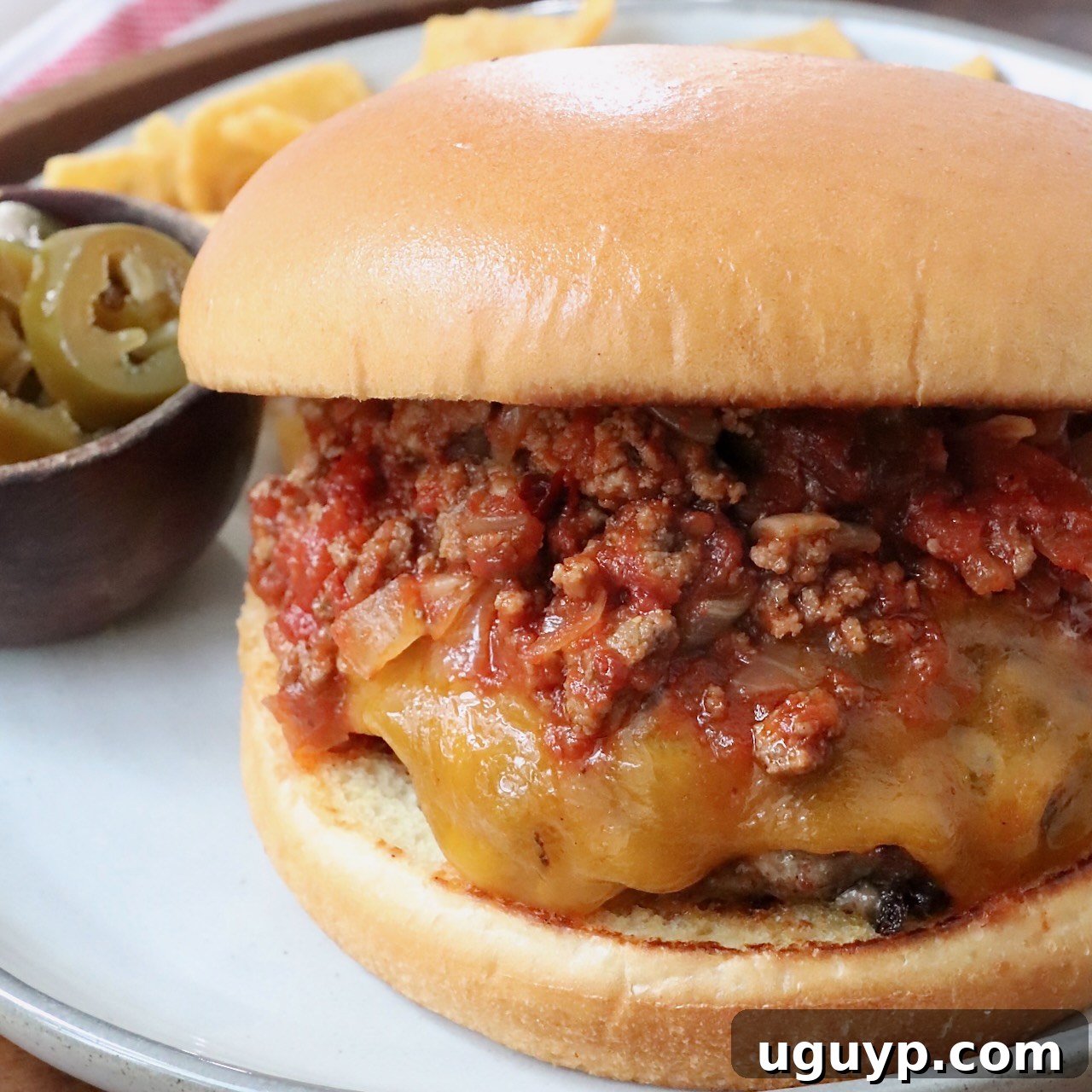 cheeseburger topped with chili on plate
