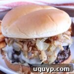 french onion burger on a plate topped with crispy onions and caramelized onions
