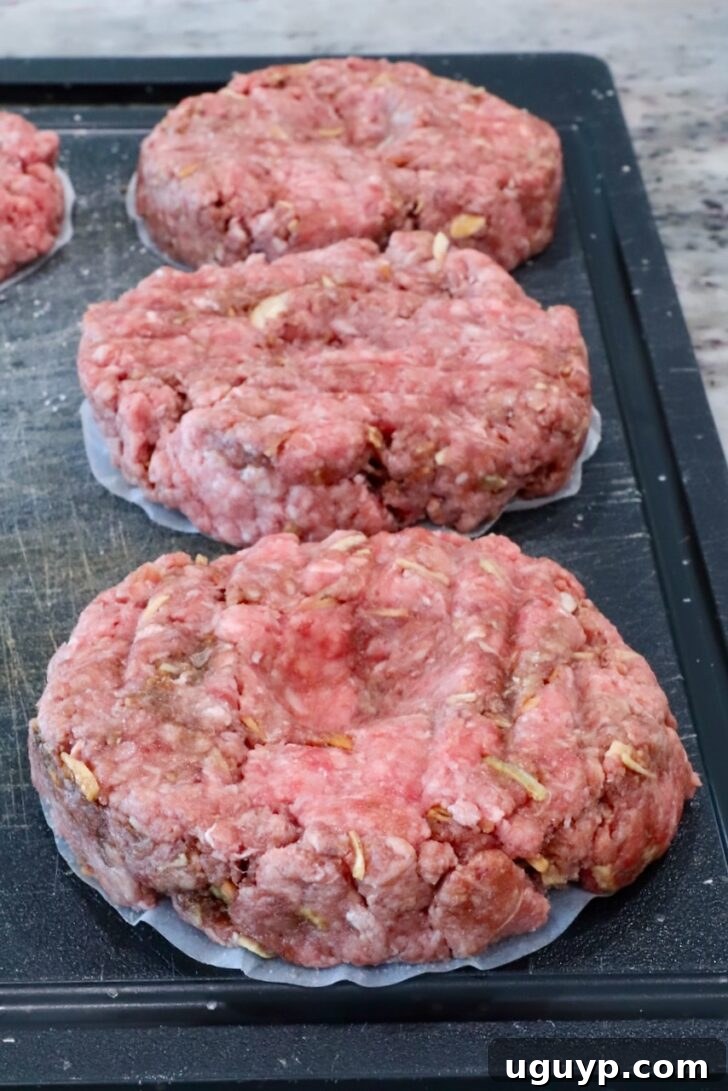 raw burger patties on a cutting board