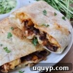Cheesy Bean & Rice Burrito Recipe – Quick Weeknight Meal 17 bean and cheese burrito cut in half and stacked up on each other on a plate