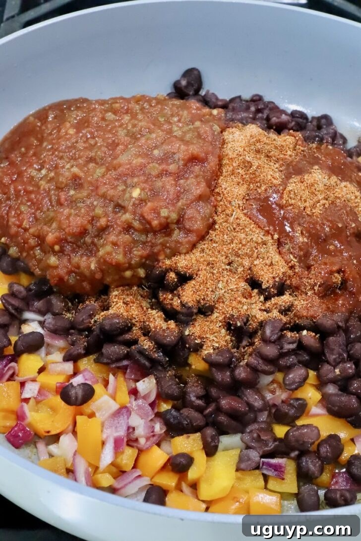 Cheesy Bean & Rice Burrito Recipe – Quick Weeknight Meal 6 diced bell pepper, onion, black beans, salsa, and taco seasoning in a skillet
