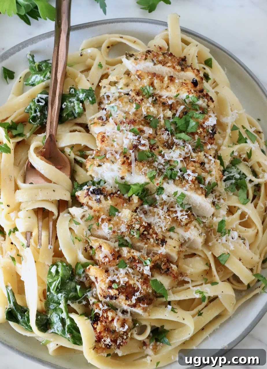 Creamy Chicken Caesar Pasta Recipe for Quick Weeknight Meals 12 chicken caesar pasta in a bowl with a fork, topped with fresh parsley and parmesan cheese