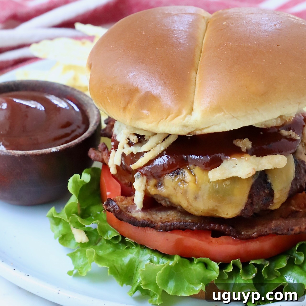 Complete Guide to Crafting Perfect Burgers at Home 16 cooked cheeseburger on plate with a side bowl of bbq sauce