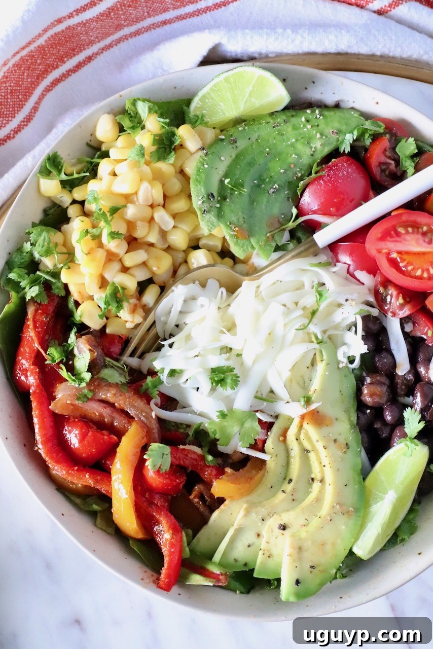 Zesty Chipotle Chicken Salad with Avocado 2 chipotle salad in a bowl topped with fajita veggies, cheese, avocado, corn, and tomatoes