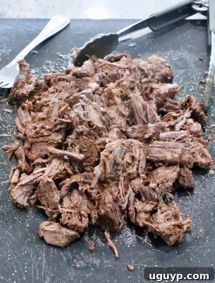 Instant Pot Beef Barbacoa - Tender Shredded Mexican Beef 11 shredded beef on a cutting board