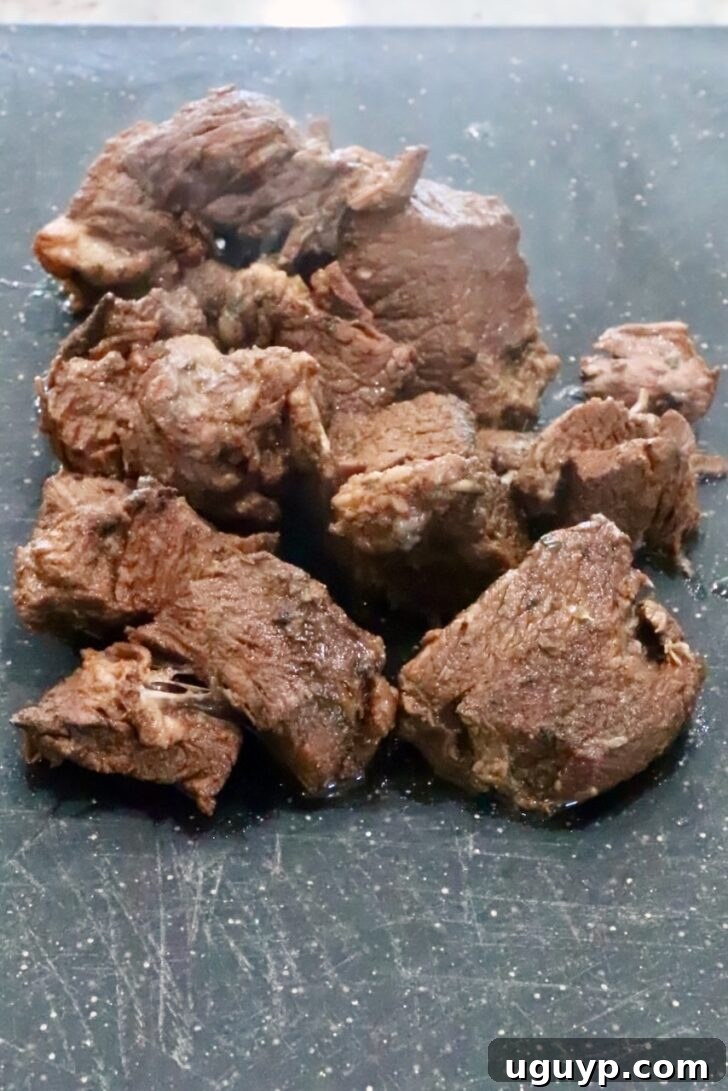 Instant Pot Beef Barbacoa - Tender Shredded Mexican Beef 10 cooked chunks of beef on a cutting board