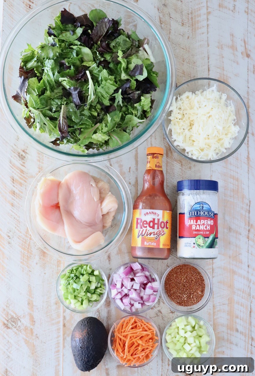 Crispy Buffalo Chicken Salad with Blue Cheese and Ranch 5 ingredients for a buffalo chicken salad on a white wood board