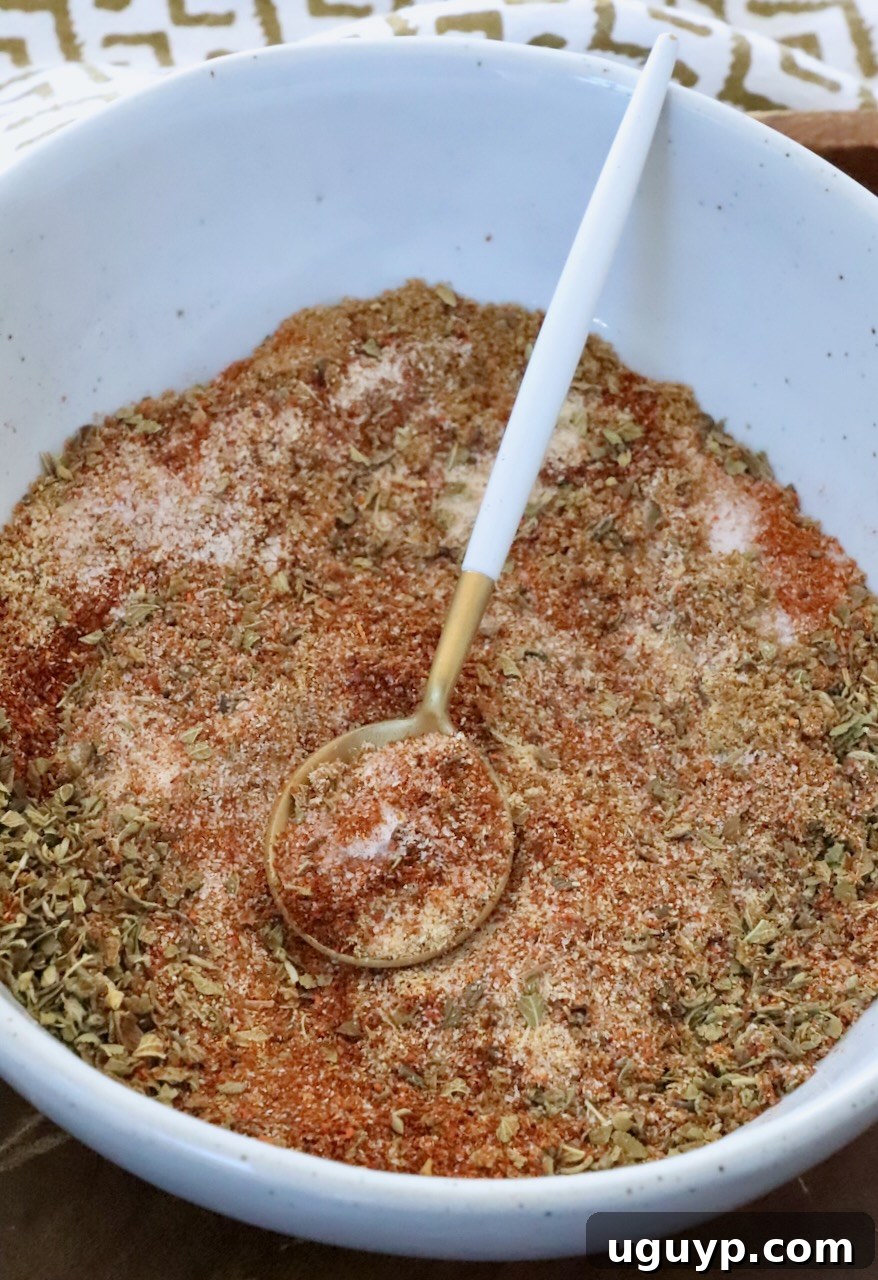 dried herbs and spices mixed together in a bowl with a spoon