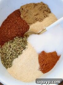 dried herbs and spices separated in a bowl with a spoon