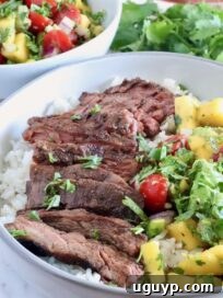 sliced steak in a bowl with mango salsa and rice