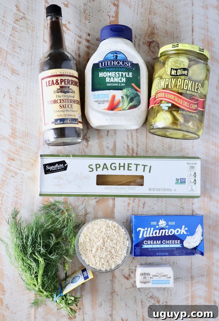 ingredients for pickle pasta with a creamy sauce on a white wood table