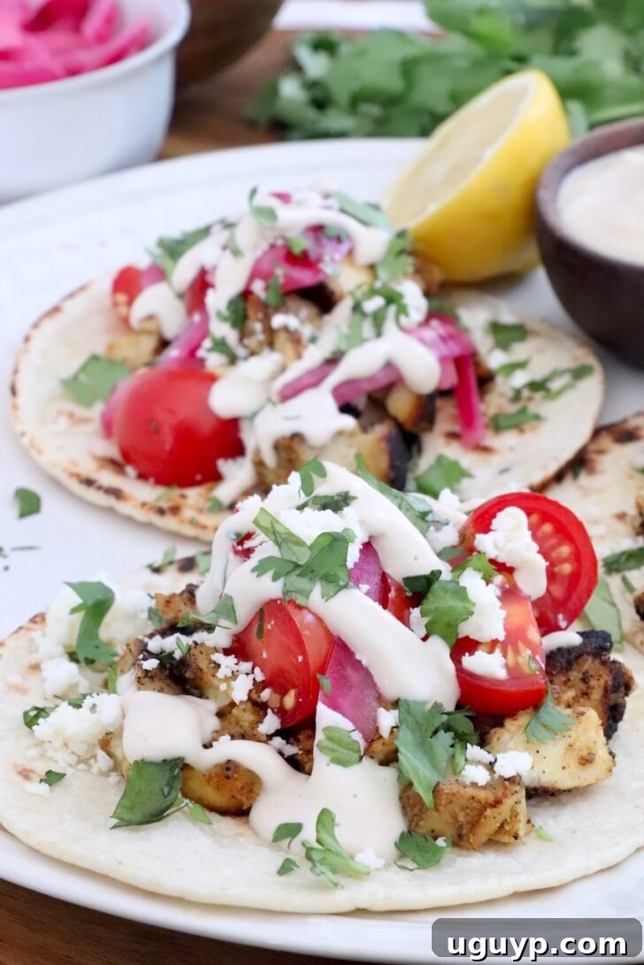 Homemade Chicken Shawarma Spice Blend 7 chicken shawarma tacos topped with garlic sauce on a plate