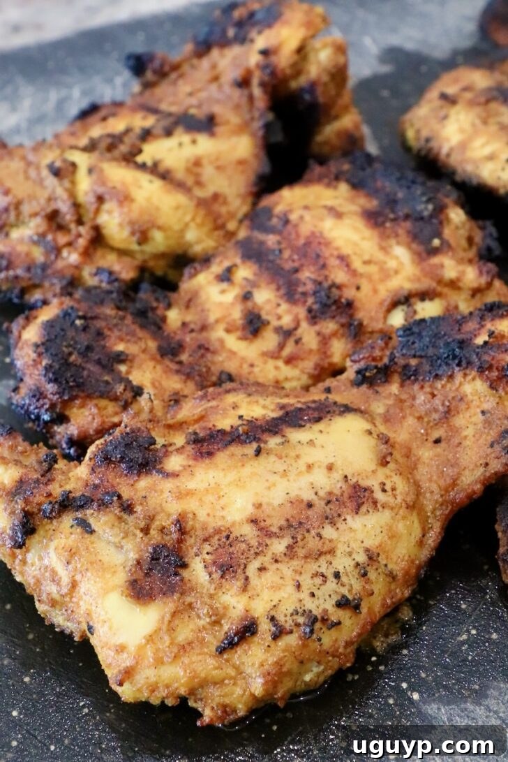Homemade Chicken Shawarma Tacos Recipe 8 grilled shawarma chicken thighs on a black cutting board