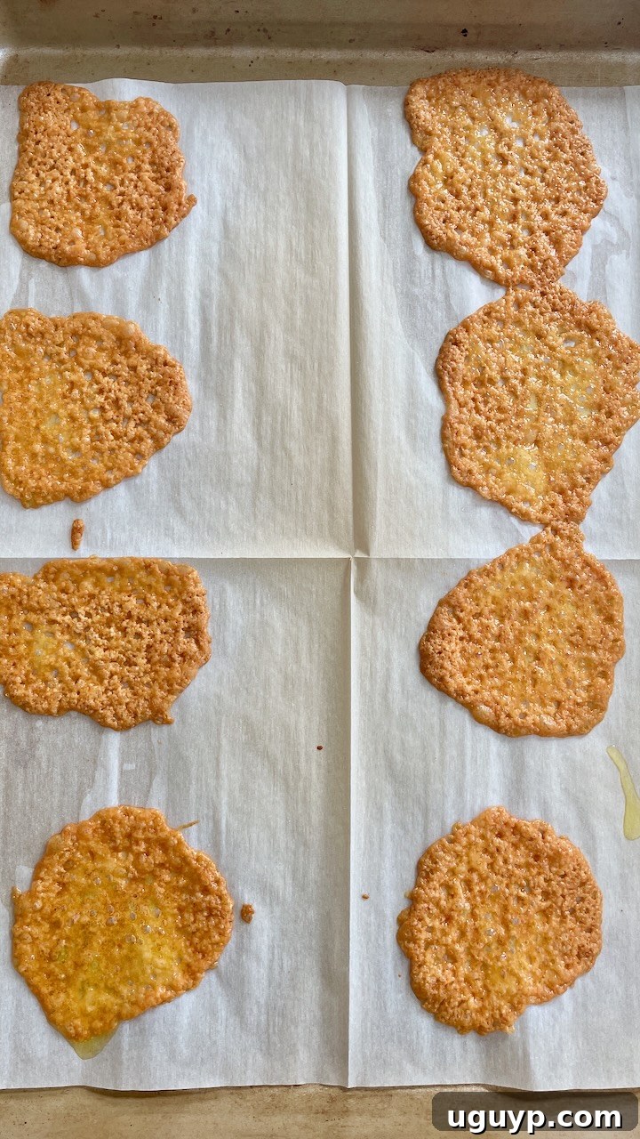 baked cheddar cheese crisps on a parchment-lined baking sheet