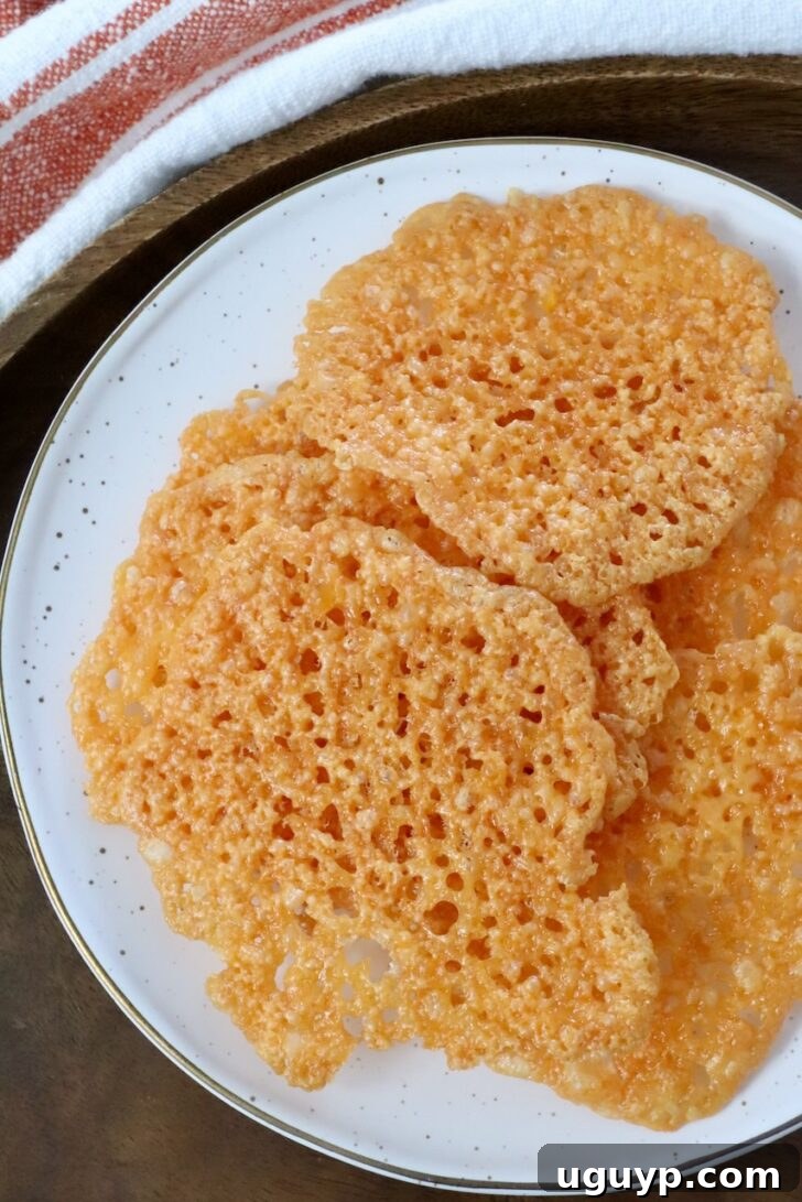baked cheddar cheese crisps stacked up on a plate