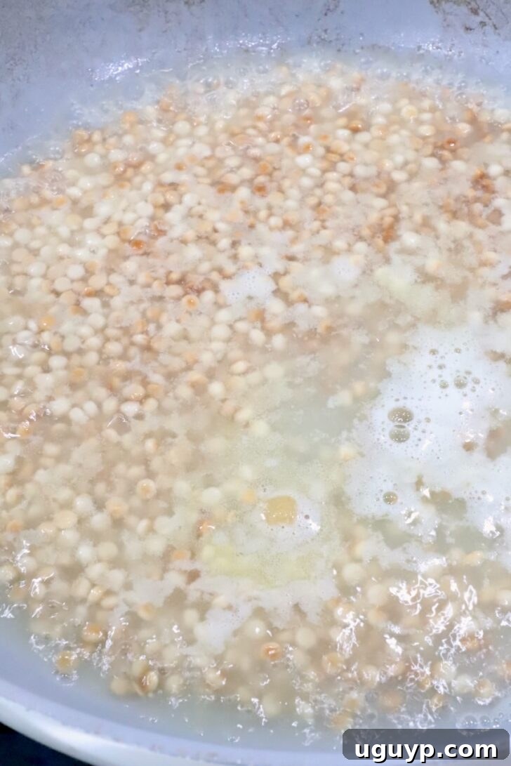 couscous simmering in water in a skillet